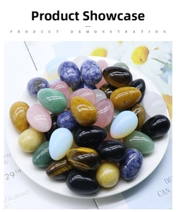 Polished egg-shaped natural crystal stones in various colors displayed on a white plate