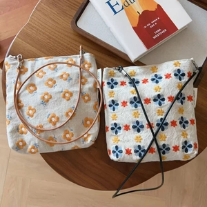 Petits sacs bandoulière vintage en toile avec broderie marguerite sur une table en bois