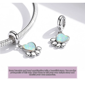 Macro detail of S925 sterling silver paw charm featuring a colorful heart-shaped opal stone