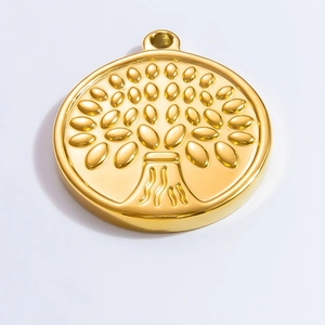 Macro detail of round golden tree of life charm with metallic textured relief surface