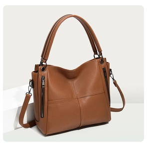 Macro detail of brown lychee texture leather and decorative metal zippers on handbag