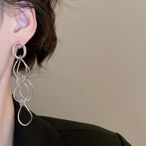 Silver geometric tassel earrings shown on model to highlight length and metallic finish