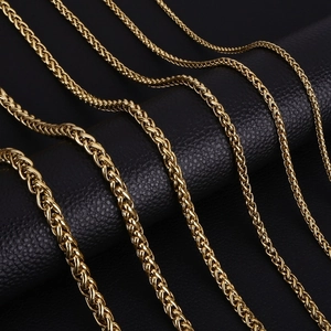 Detailed macro view of golden wheat chains in various thicknesses on black leather