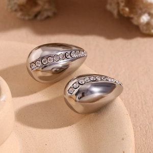 Macro detail of silver-tone teardrop earrings featuring a centered line of clear rhinestones