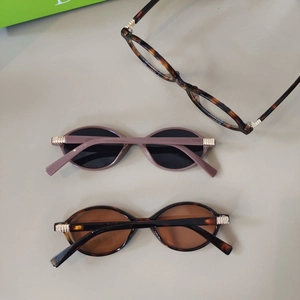 Close-up of retro cat-eye sunglasses with gold textured hinges and tortoiseshell frames