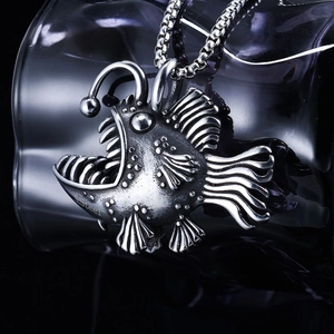 Macro view of a vintage stainless steel anglerfish pendant with silver finish on a chain