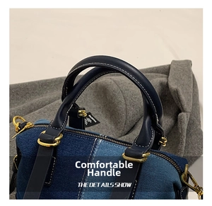Detail of denim patchwork bag with dark blue leather handles and gold metal hardware