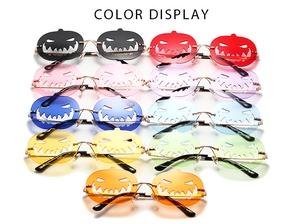 Detailed color display of pumpkin shaped rimless Halloween sunglasses with metal temples