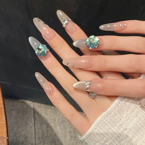 Sparkling cat eye press-on nails with blue gemstone accents and glittering rhinestones