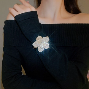 Detail of adjustable flower bracelet with silver rhinestones on black knit fabric