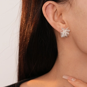 Gros plan d'une boucle d'oreille minimaliste en argent avec zircone radiante
