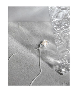 Macro shot of S925 silver shell pearl pendant with liquid metal design on stone surface