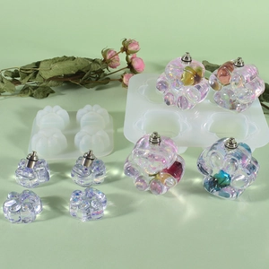Detailed view of cat paw silicone molds and finished iridescent resin crafts with dried flowers