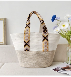 Close-up of bohemian woven tote bag with colorful geometric ribbon handles and natural straw texture