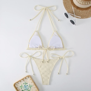 Close-up of off-white bikini with grid texture and elegant tie straps on white background