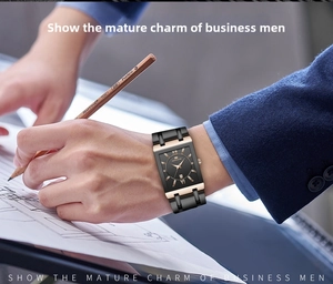 Close-up of square gold and black business quartz watch with date window on male wrist