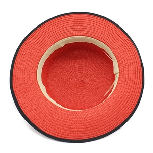 Internal view of red straw hat showing spiral weaving and black trim finish