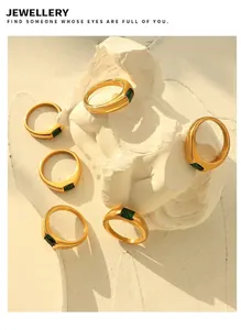 Artistic layout of 18K gold plated rings with green rectangular zircons on white sculptures