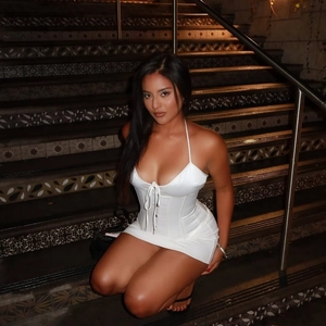 Mini-robe dos nu élégante blanche en satin sans manches avec laçage sur escalier