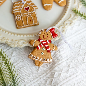 Cute gingerbread man and house Christmas tree ornaments with red bows and white icing