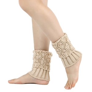 Detailansicht der beigen grob gestrickten Beinstulpen mit Textur und Umschlag am Bein