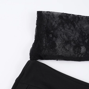 Détail du haut moulant noir avec coutures en dentelle délicate et découpe au niveau du col