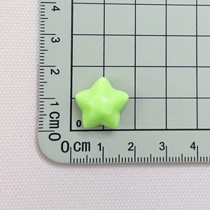 Detail showing a 1.5cm light green star resin bead with a ruler for size measurement