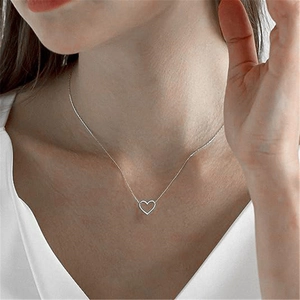 Close-up of minimalist S925 sterling silver heart pendant necklace on a female model