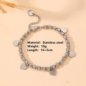 Polished stainless steel heart bracelet with crystal pendant on a soft pink background