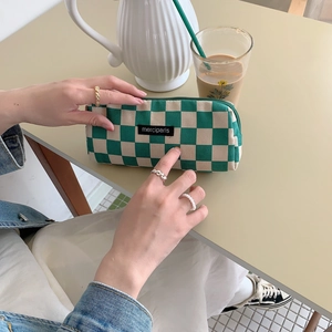 Detail shot of green checkered canvas pouch with merciparis label and matching zipper