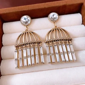 Orecchini vintage dorati con nappe in zircone all'interno di un portagioie in velluto