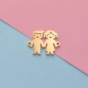 Polished gold boy and girl cartoon pendants with side loops on a pastel background