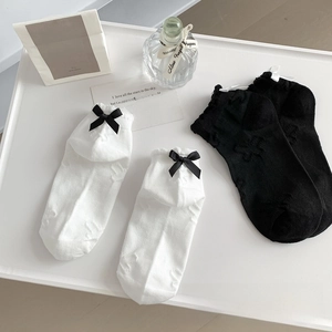 Close-up of JK style lace socks with bow ties and 3D floral embossed texture in white and black