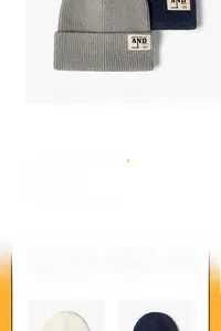 Vue détaillée de la texture du bonnet tricoté et de l'écusson avec lettre 'AND' cousue
