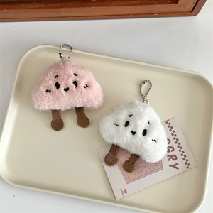 Dettaglio di ciondoli a fungo in peluche rosa e bianco con pelliccia morbida e catenella