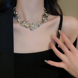 Detail of silver irregular lava style metal necklace on model with polished finish