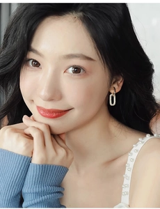 Nahaufnahme eleganter ovaler Ohrstecker mit glitzerndem Zirkonia am Ohr des Models