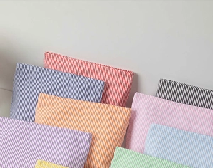 Detailed close-up showing multiple colors of seersucker striped travel makeup bags