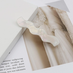 Iridescent pearl white wavy acetate hair clip with mother-of-pearl luster on stone base