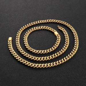 Polished golden Cuban link chain for men in a spiral layout on a textured black background
