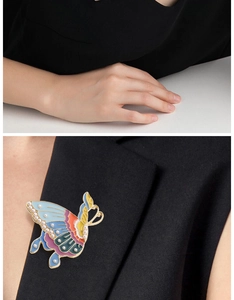 Detail of colorful butterfly brooch with enamel glaze and mini pearls on black blazer lapel