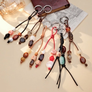 Detailed close-up of handmade woven phone strap with ethnic beads and metal ring