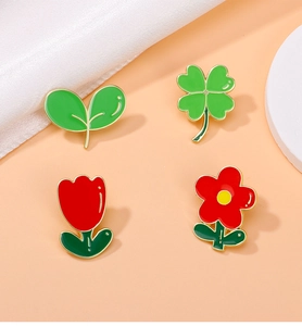 Vue détaillée de 4 broches en émail floral coloré sur un fond orange chaleureux