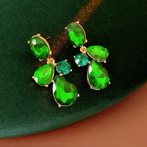 Macro shot of vintage style green crystal drop earrings with gold metal setting