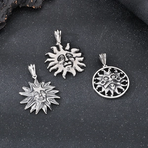 Close-up of vintage silver sun face pendants with detailed engraving in stainless steel
