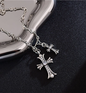 Macro shot of silver cross pendants with cubic zirconia inlay and retro twisted chain