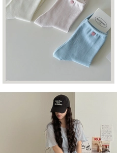 Detail view of cream-style mid-calf cotton socks in beige, gray and blue with shell buttons