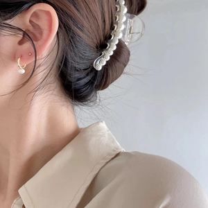 Elegant gold pearl earrings and matching hair claw clip set worn by a female model