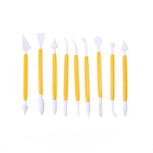 Detail of 9-piece yellow sculpting tool set for fondant cake and clay carving on white background
