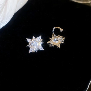 Detail view of silver star ear cuff featuring sparkling cubic zirconia on a black background
